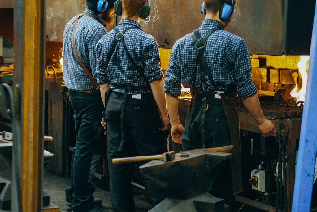 Apprentis ferronniers d'art qui portent notre pantalon de travail traditionnel